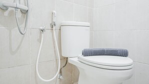 Ein Badezimmer mit Toilette, Dusche und Handtuch.