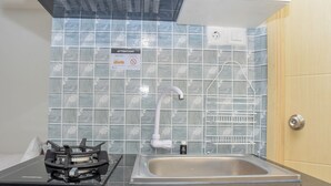 Una cucina con piano cottura a gas, lavello e schienale piastrellato.