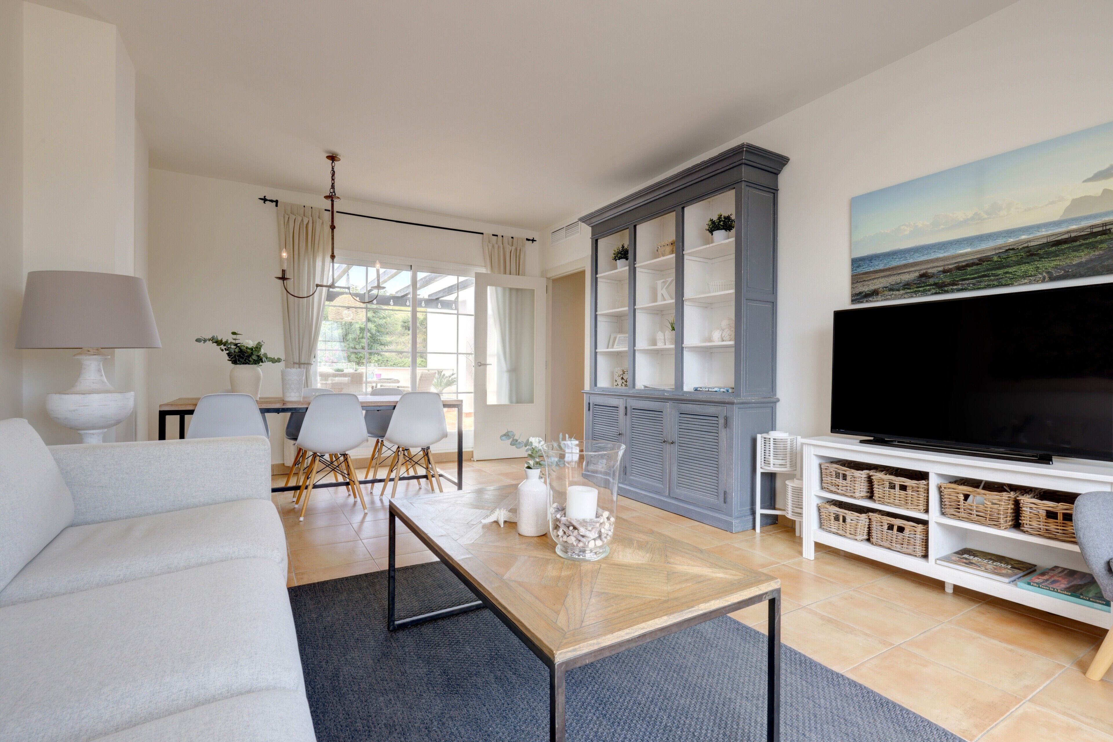 Una sala de estar con sofá, mesa de centro, televisor y un mueble con estantes.