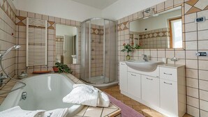 Une salle de bain équipée d’une baignoire, d’une douche, d’un lavabo et d’un meuble-lavabo.
