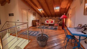 Un intérieur en bois avec un escalier, un canapé, une table et une lampe.