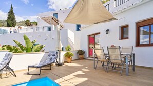 A poolside area with lounge chairs, a table, and potted plants. - Cottage "Casa Loli" with Mountain View, Private Pool & Terrace (Frigiliana)