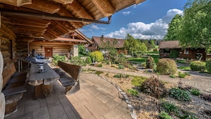 A wooden cabin with a dining area and a garden view. - Natural log house Morgensonne - Heumann's log houses by the forest (Pottenstein)