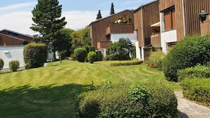 A modern building with a flat roof, large windows, and a well-maintained lawn. - Apartment - Apartment Kreckel (Schliersee)