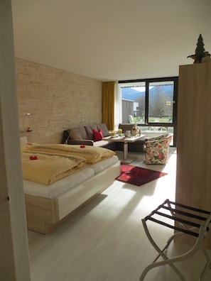 Un dormitorio moderno con cama, sofá y zona de comedor con mesa y sillas.