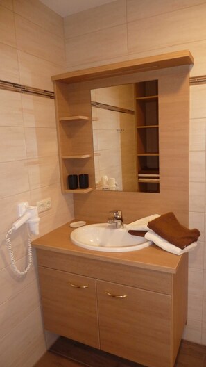 A bathroom with a sink, mirror, and wooden cabinet. - Vacation apartment Rettenkogel - Maislbauer (St. Wolfgang im Salzkammergut)