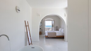 Un dormitorio moderno con una cama grande, vistas al mar y un diseño minimalista.