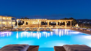 Una piscina con sillas de descanso y una zona de bar.