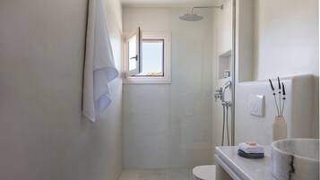 A modern bathroom with a shower, toilet, and a sink with a marble basin.
