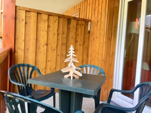 Eine Holzwand mit einer kleinen Holz-Weihnachtsbaum-Dekoration auf einem Tisch.