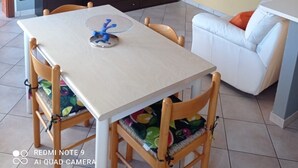 A dining area with a table, chairs, a TV, and a sofa. - House at Nonna Pina's at the gateway to the Val Grande (Cossogno)