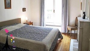 Ein Schlafzimmer mit einem Bett, einem Nachttisch, einem Schreibtisch und einem Sessel.