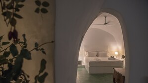A bedroom with a bed, bedside table, lamp, and ceiling fan. - Hiraeth: Stylish canava house with pool and garden (Μεγαλοχώρι)