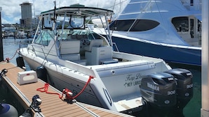Un port esportiu amb embarcacions amarrades, incloent-hi un iaiot blanc amb la inscripció 'Keys Largo' i 'Yamaha 300' als costats.