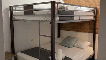 A bunk bed room with a small table and a wall-mounted air conditioner.