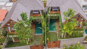 A modern house with a sloped roof, multiple windows, and a small garden area with various plants and flowers.