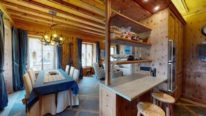 L’intérieur d’un chalet en bois comprend un coin repas, une cuisine et un bar.