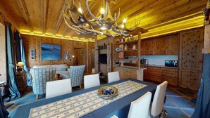 Un intérieur en bois comprenant un coin repas, un téléviseur et une cuisine.
