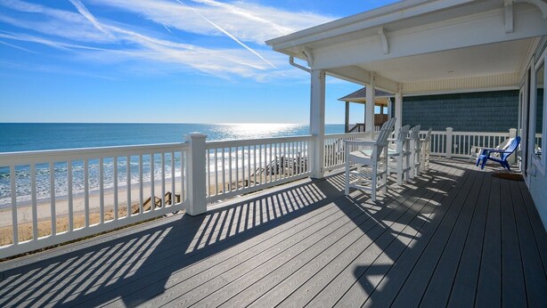 A wooden deck with a white railing overlooking a beach. - Sandy Paradise: An oceanfront, 6-bedroom retreat in Surf City, perfect for 20 guests! (Surf City)