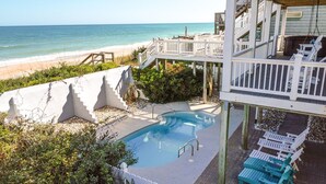 A pool area with a view of the beach, surrounded by white railings and greenery. - Sandy Paradise: An oceanfront, 6-bedroom retreat in Surf City, perfect for 20 guests! (Surf City)