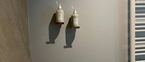 Dos botellas de champú y acondicionador sobre una pared.