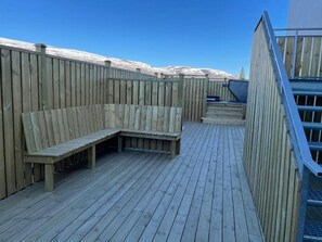 Enjoy the serene atmosphere from this deck with a bench and steps leading to a higher level.