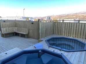 Relax on the deck with a hot tub and seating area overlooking the city.
