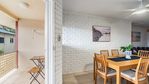 Un coin repas avec un mur en briques, une table en bois et des chaises.