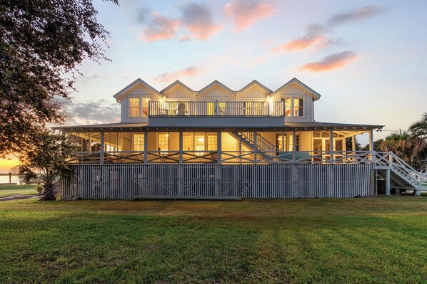 A two-story house with a balcony, a staircase, and a covered porch.