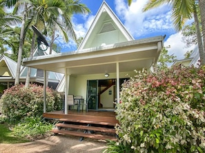 A house with a covered porch, a staircase, and a garden with various plants.