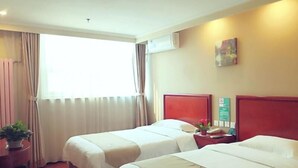 A hotel room with two beds, a small table with a plant, and a window with curtains. - Greentree Inn Beijing Tongzhou Tuqiao Subway Station Express Hotel (Tongzhou)