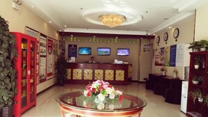 A hotel reception area with a glass-top table in the center, a reception desk, and a television screen. - Greentree Inn Beijing Tongzhou Tuqiao Subway Station Express Hotel (Tongzhou)