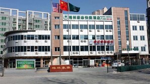 A multi-story hotel with a prominent sign in the center. - Greentree Inn Beijing Tongzhou Tuqiao Subway Station Express Hotel (Tongzhou)