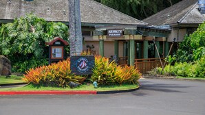 A building with a sign reading "Keoki's Paradise" surrounded by tropical plants. - 1Br 1Ba Kahala Tropical Dream, Pool, Garden View 513 (Koloa)