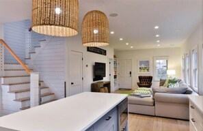 Staircase leads to a cozy landing area with a flat-screen TV and comfortable seating.