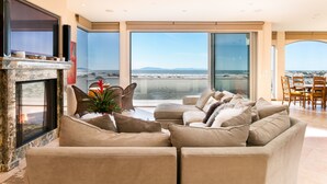 Uma sala de estar moderna com lareira, assentos confortáveis e janelas amplas com vista para a paisagem.