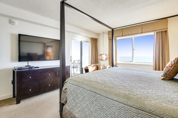 A bedroom with a bed, a television on a dresser, a window with curtains, and a view of the ocean. - Sandy Key 414: 2 BR / 2 BA Gulf Front Condo in Perdido Key, FL Sleeps 6 (Pensacola)