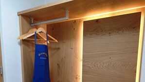 A wooden wardrobe with a hanging rod and a shelf. - Binterhof vacation apartment GENZIANA (Trentino-Alto Adige)