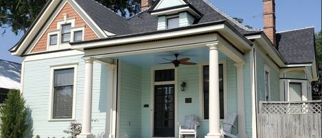 A two-story house with a porch, a chimney, and a front yard.