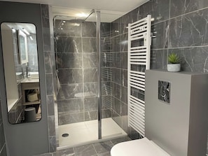 A modern bathroom with a glass-enclosed shower, a white sink, and a towel rack. - Charming and stylish vacation homes (Tardinghen)