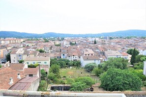 Un'area urbana densamente popolata con edifici residenziali addossati, qualche spazio verde e una catena montuosa in lontananza.