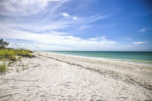 A sandy beach with a clear sky and calm sea.