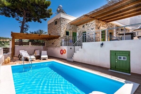 A swimming pool with a stone building in the background. - Aggel's House - stone house - private pool - courtyard - countryside views (Kato Episkopi)