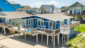 Une maison située en bord de mer, dotée d’un balcon, d’une piscine et d’une terrasse.