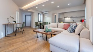 Ein modernes Wohnzimmer mit Sofa, Couchtisch und Essbereich.