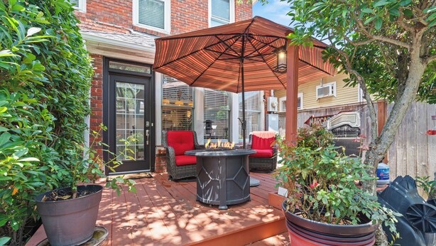 Une terrasse avec un foyer extérieur, du mobilier de jardin et des plantes en pot.