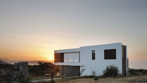 A modern two-story building with a flat roof, large windows, and a stone facade. - Impeccable design, total privacy & heated pool with sea views (Rethymno)