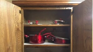 A wooden cabinet with shelves containing kitchenware. - Fort Sill visitor entrance half a mile! (Lawton)
