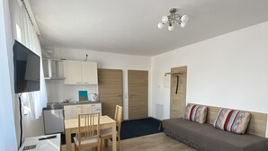 A compact living space with a kitchenette, a dining area, and a sofa. - MyHome10, Wiesbaden-Mainz, Apartment No: 6 (Wiesbaden)
