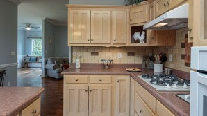 Una cocina con armarios de madera, estufa a gas y una encimera.